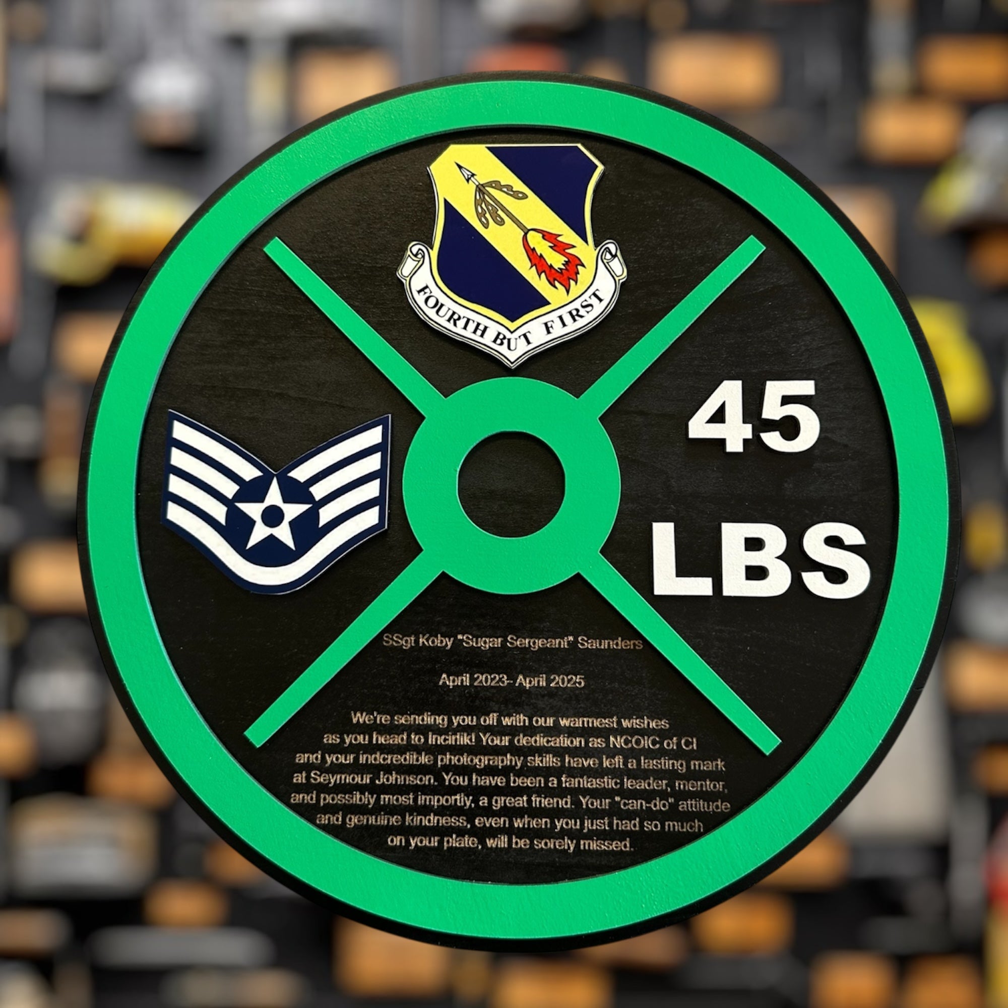 Weight plate military gift  with symbols and text on a blurred gym background