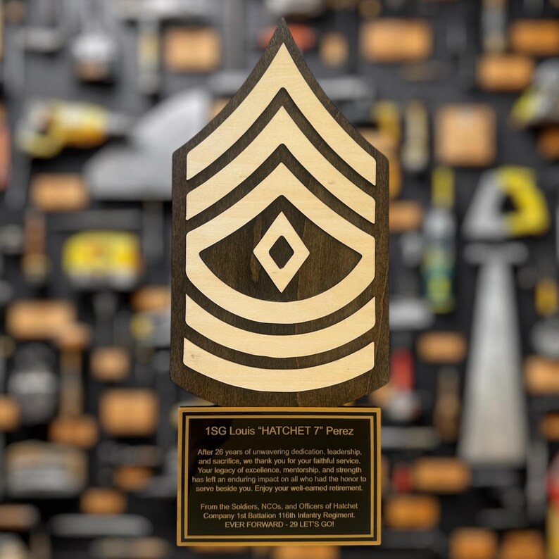 Wooden military rank insignia with a plaque on a blurred background of similar insignias.